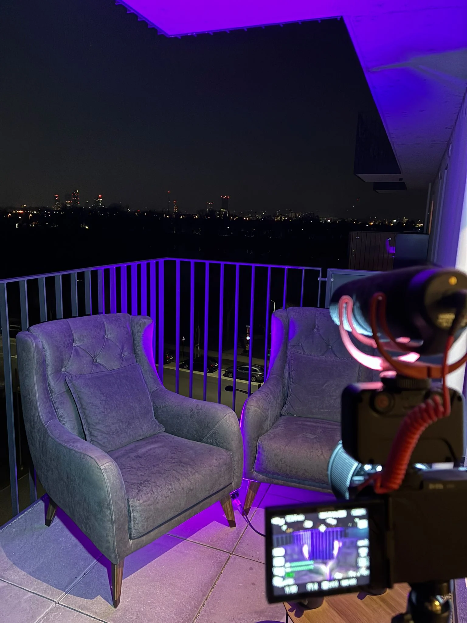 Zwei Samtsessel auf einem Balkon über Wien bei Nacht